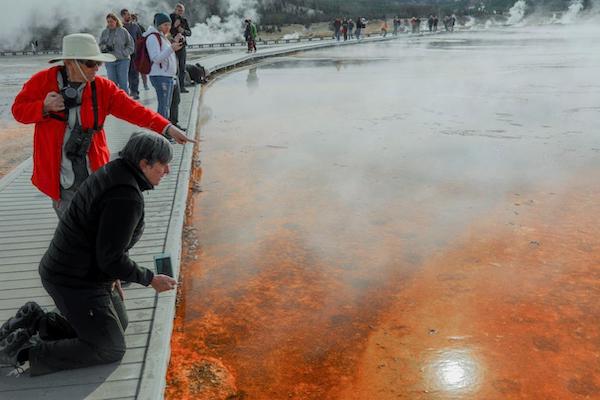 Nat Hab travelers looking into orange waters of Grand Prismatic Spring