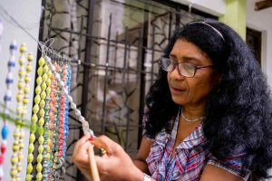 Artisan Daisy Patiño displays her work for Paper to Pearls