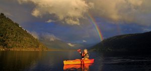 Woman solo traveler kayaking in New Zealand Lake Moeraki New Zealand
