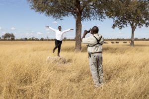 Nat Hab guest woman poses on top of rock in African savanna