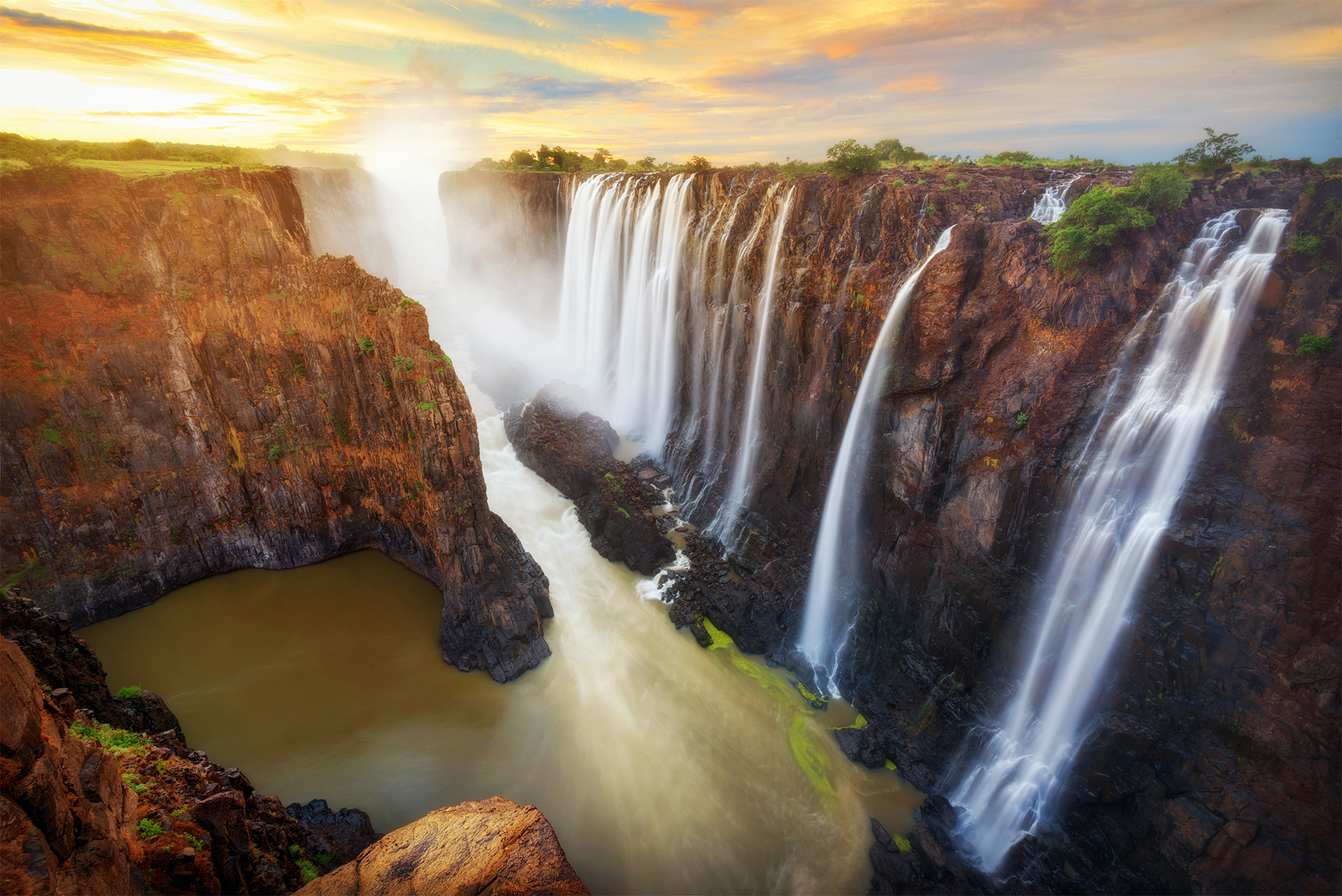 Muddy waters of Victoria falls in Zimbabwe Southern Africa slow shutter speed silky water at sunset