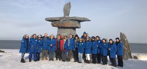 Nat Hab travelers stand in front of an Inukshuk in Churchill, Canada