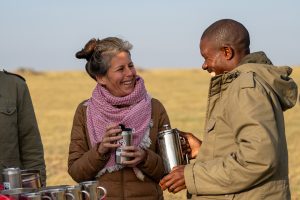 Nat Hab traveler enjoys a morning coffee using our reusable thermos mugs. Sustainability is our priority even on safari in Tanzania