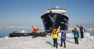 Nat Hab travelers wave in front of the Hanse Explorer