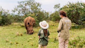 Back view of family on safari walking close to white rhino
