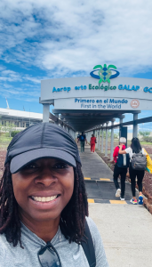 A smiling woman takes a selfie in front of airport